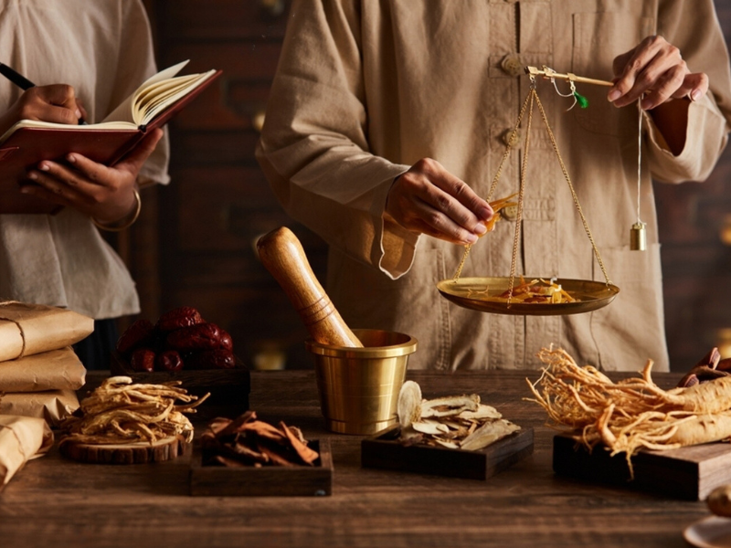 Measuring Herbal Mojo for Guys ingredients in gold scale on wooden table